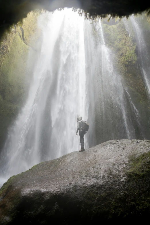 a person standing in front of a waterfall, by Hallsteinn Sigurðsson, hurufiyya, walking down, up-close, fully functional, historical