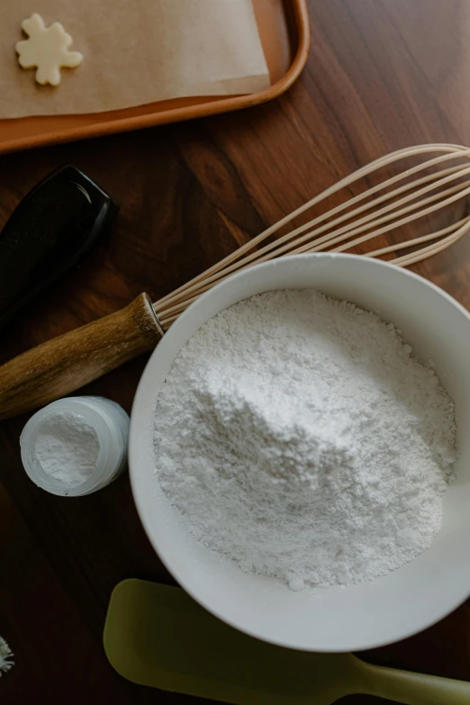 a wooden table topped with a bowl of flour and a whisk, by Ben Zoeller, trending on pexels, made of glazed, botanicals, detailed product image, shoulder