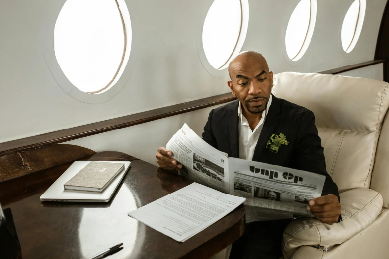 a man sitting in a chair reading a newspaper, a portrait, pexels contest winner, private press, aircraft, jeffrey wright, inside a grand, trevor phillips