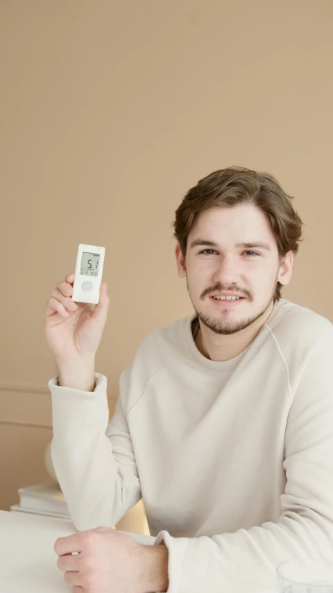 a man sitting at a table holding a game controller, inspired by Jonas De Ro, godlike temperature, low quality photo