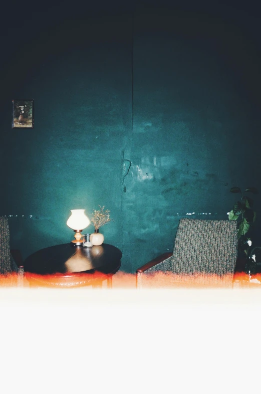 a table with a lamp sitting on top of it, an album cover, inspired by Elsa Bleda, waiting room, low quality photo, lo fi, night photo