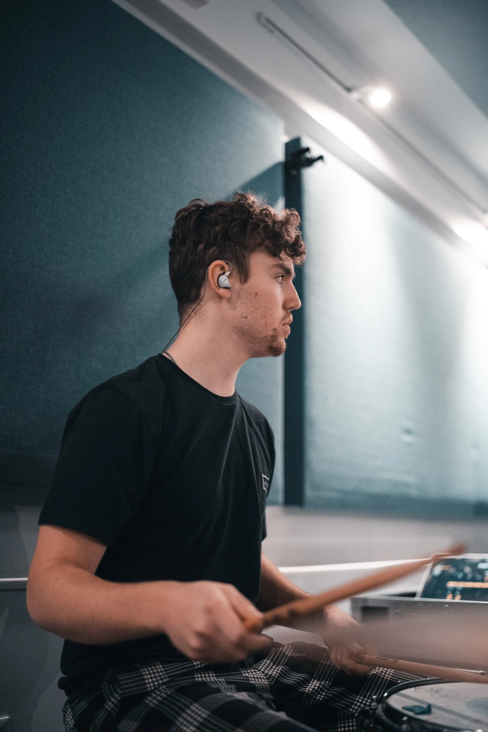 a man playing drums in a recording studio, inspired by Seb McKinnon, unsplash, side profile portrait, earbuds, charli bowater, profile image