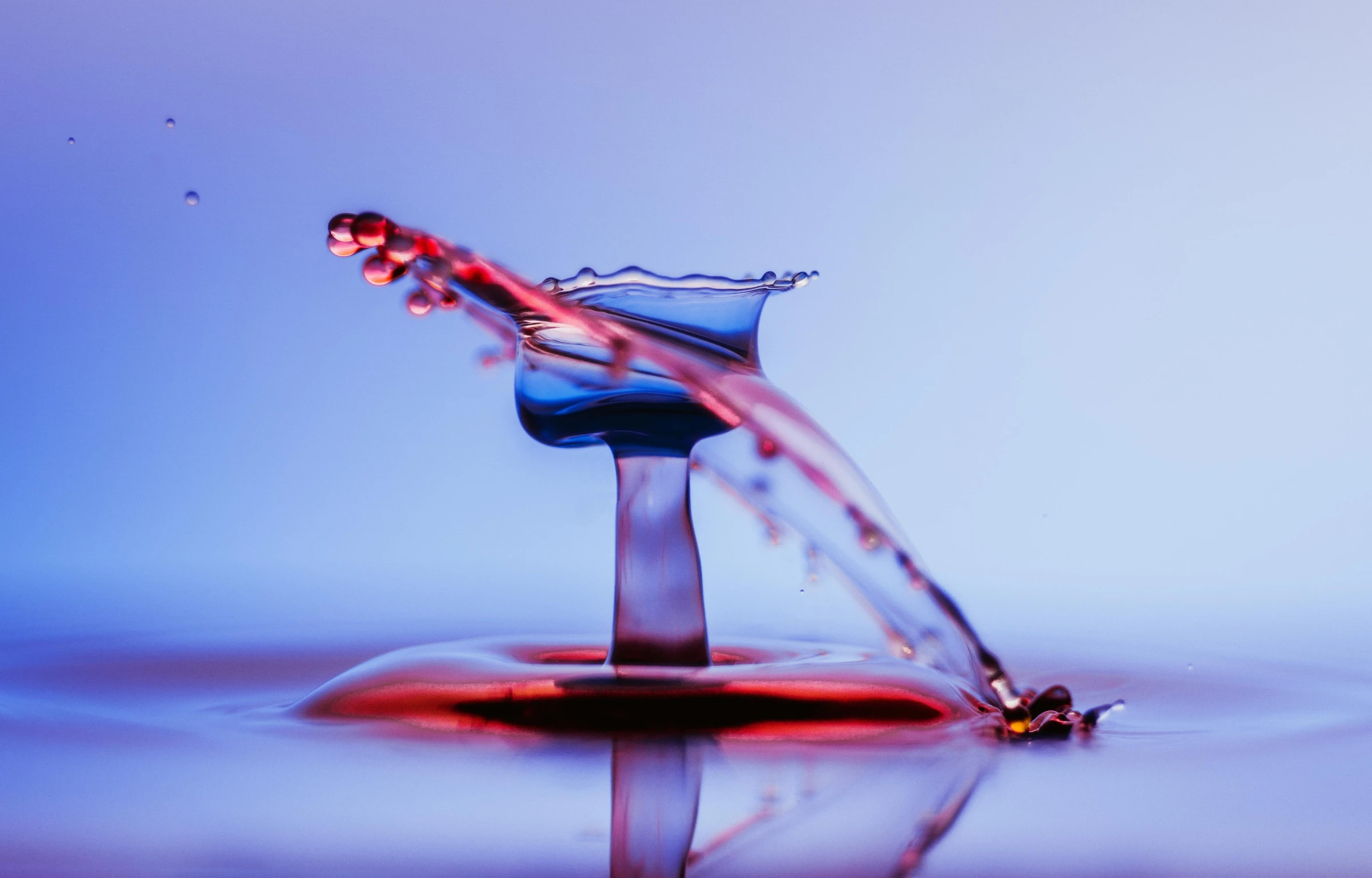 a water drop falling into a body of water, an album cover, by Doug Ohlson, pexels contest winner, red and blue color scheme, glassware, whirling, take off