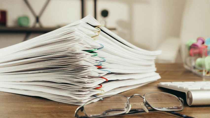 a stack of papers sitting on top of a wooden table, wire management, multiple stories, thumbnail, iso