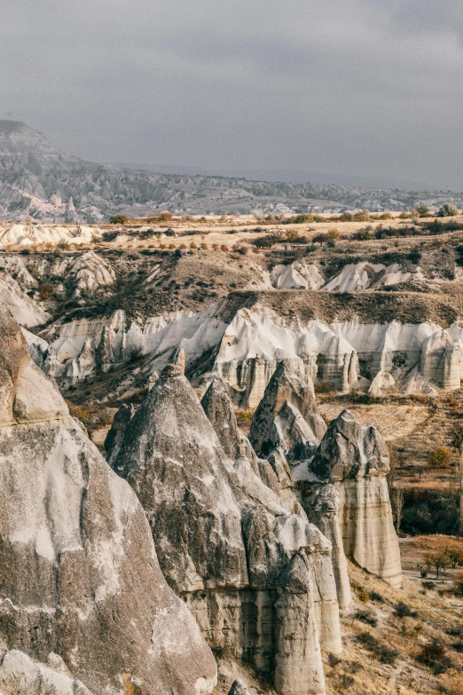 a person standing on top of a rock formation, trending on unsplash, baroque, turkey, gigapixel photo, rolling foothills, spires