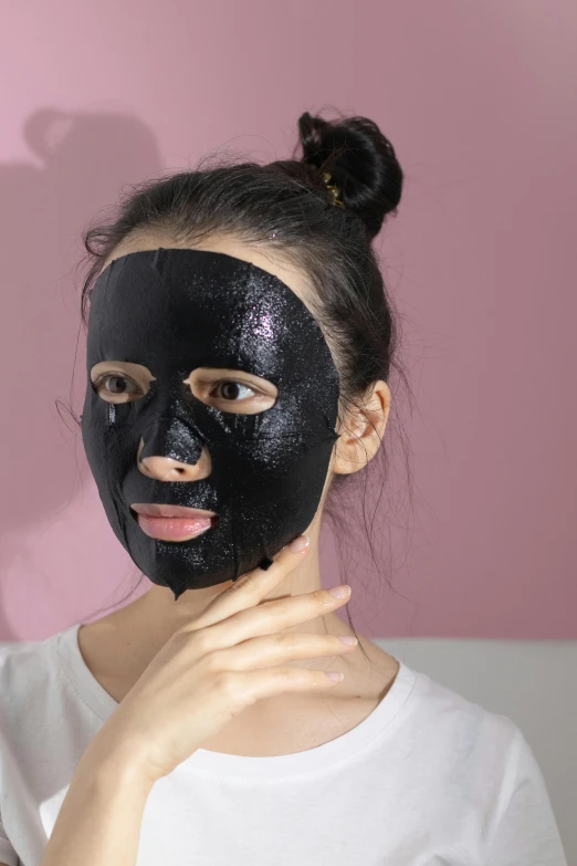 a woman putting a black mask on her face, eora, front on, pearlescent skin, basic