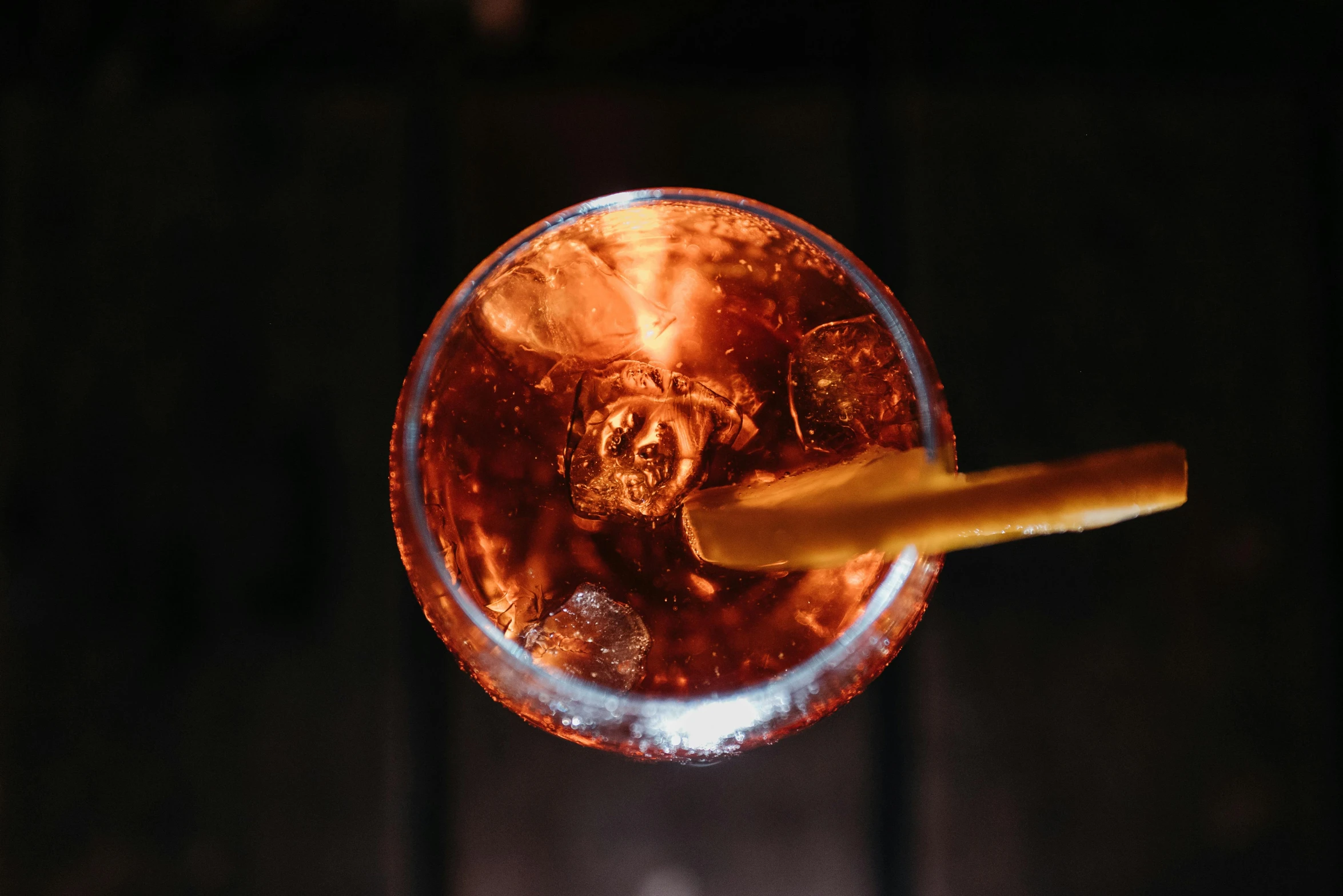 a close up of a drink in a glass with a straw, pexels contest winner, renaissance, black and auburn colour pallet, birdseye view, glowing amber, gif