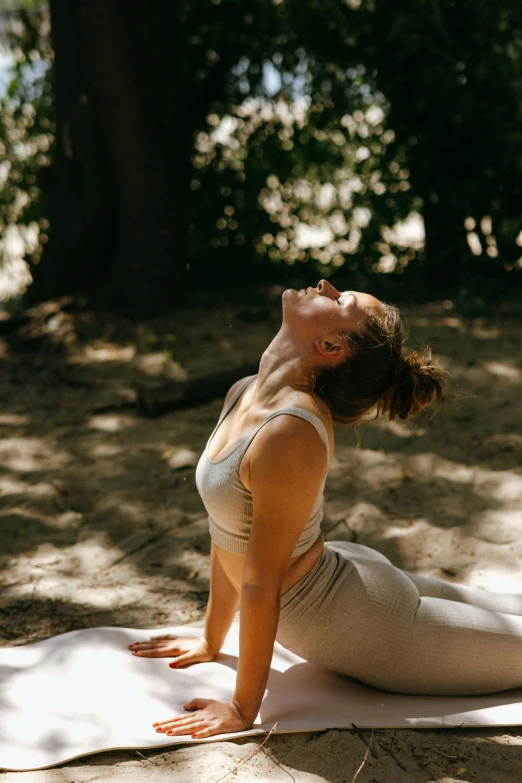 a woman doing a yoga pose in the woods, a picture, unsplash, sunbathed skin, head tilted down, arched back, profile image
