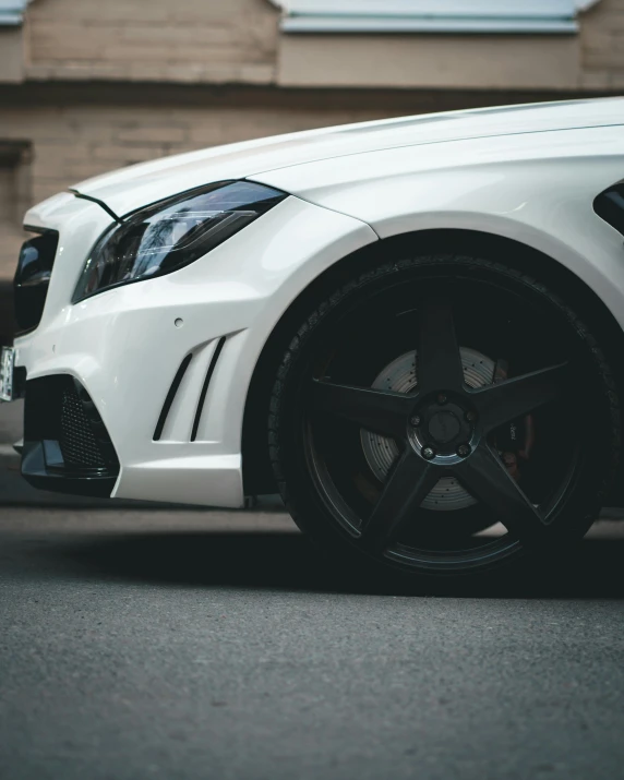 a white car parked in front of a building, by Adam Marczyński, black wheel rims, dynamic closeup, with a white muzzle, thumbnail