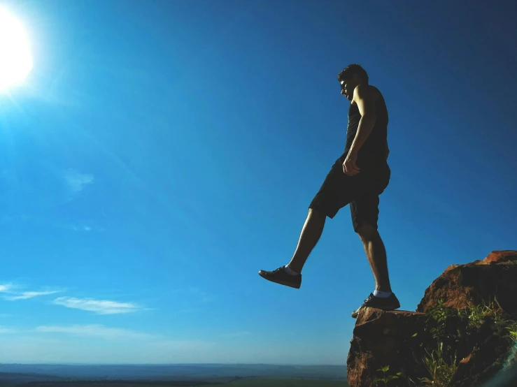 a man standing on top of a large rock, pexels contest winner, figuration libre, on a hot australian day, leg high, profile pic, clear blue skies