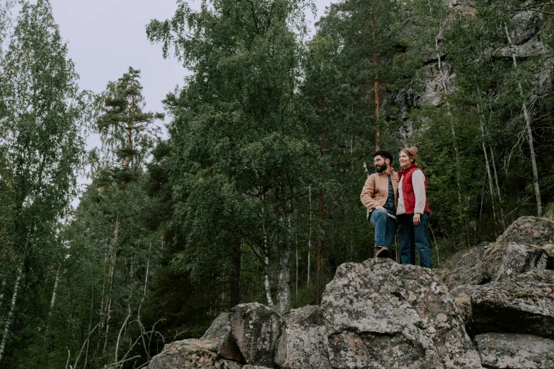 a man and a woman standing on top of a rock, by Eero Järnefelt, unsplash, hurufiyya, forest picnic, teaser, lookbook, item