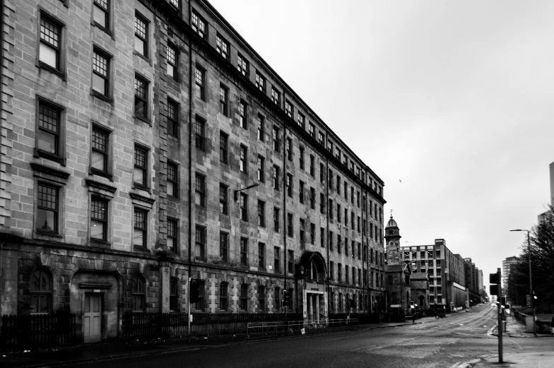 a black and white photo of a city street, inspired by Thomas Struth, pexels contest winner, abandoned hospital, paisley, building facing, riverside