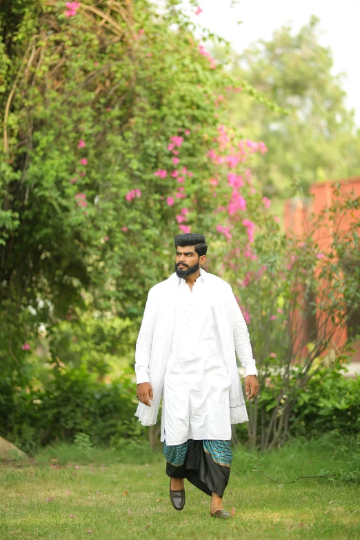 a man walking across a lush green field, by Riza Abbasi, renaissance, wearing lab coat and a blouse, wearing a kurta, portait image, in garden