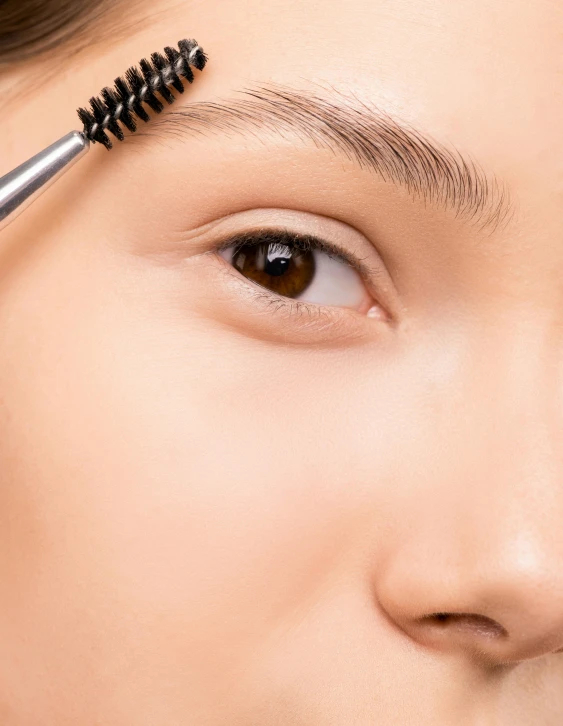 a close up of a person with a mascara brush, groomed eyebrows, product image, brown, asian face