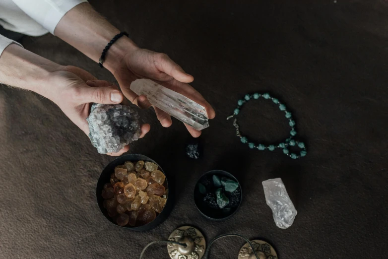 a person holding a rock in their hands, a still life, trending on pexels, with crystals on the walls, fortune teller, alchemical equipment, épaule devant pose