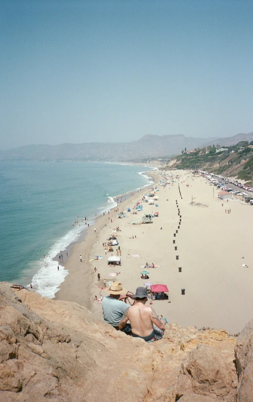 a group of people sitting on top of a sandy beach, inspired by Thomas Struth, unsplash, renaissance, malibu canyon, view from high, a blond, bustling with people