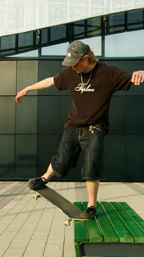 a man riding a skateboard on top of a green bench, a picture, by Dave Allsop, dribble, jeans and t shirt, brown:-2, black t - shirt, style game square enix