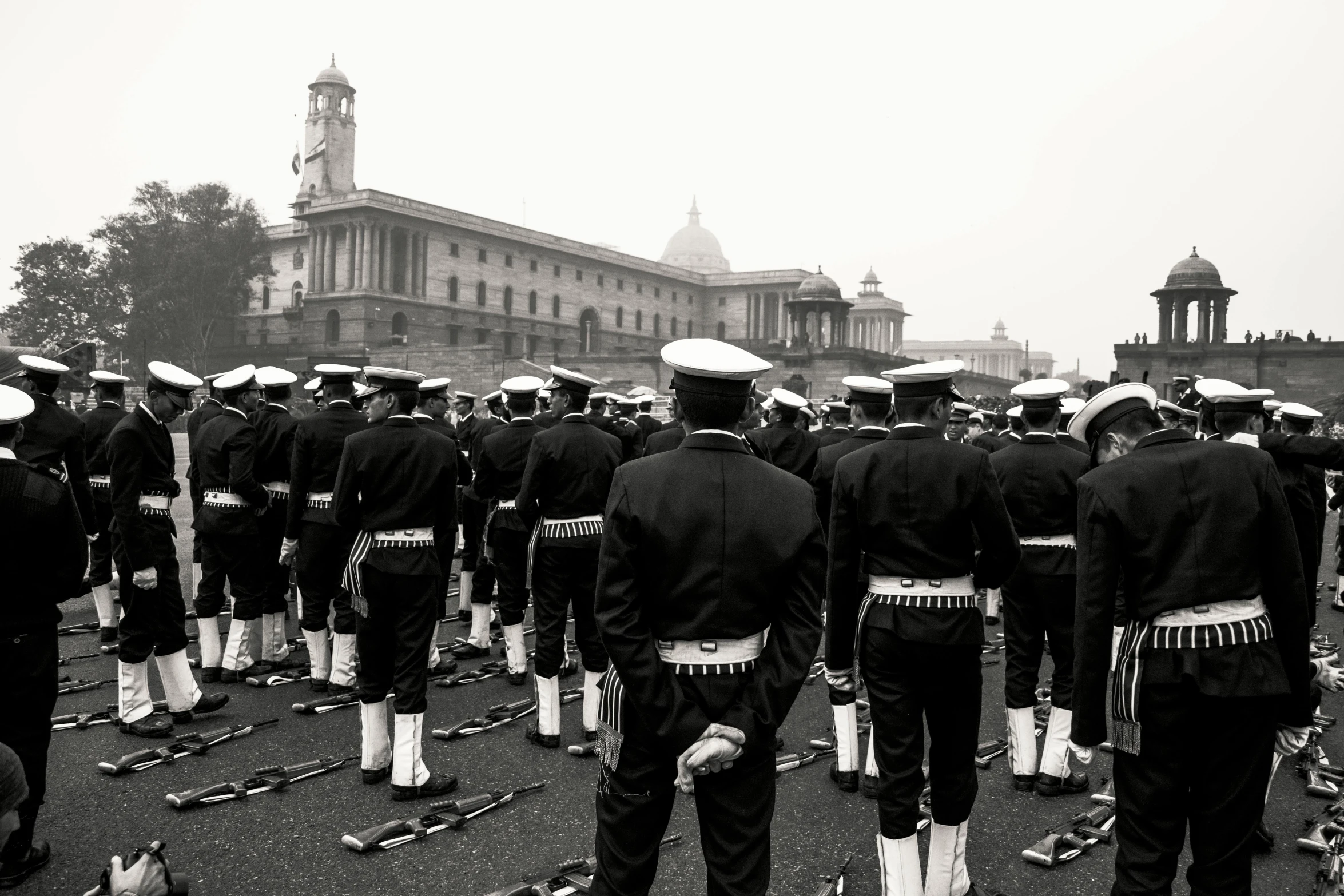 a black and white photo of a marching band, by Kevin Connor, pexels contest winner, sots art, naval landscape, india, in muted colours, looking in front