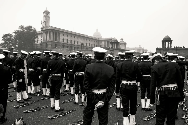 a black and white photo of a marching band, by Kevin Connor, pexels contest winner, sots art, naval landscape, india, in muted colours, looking in front