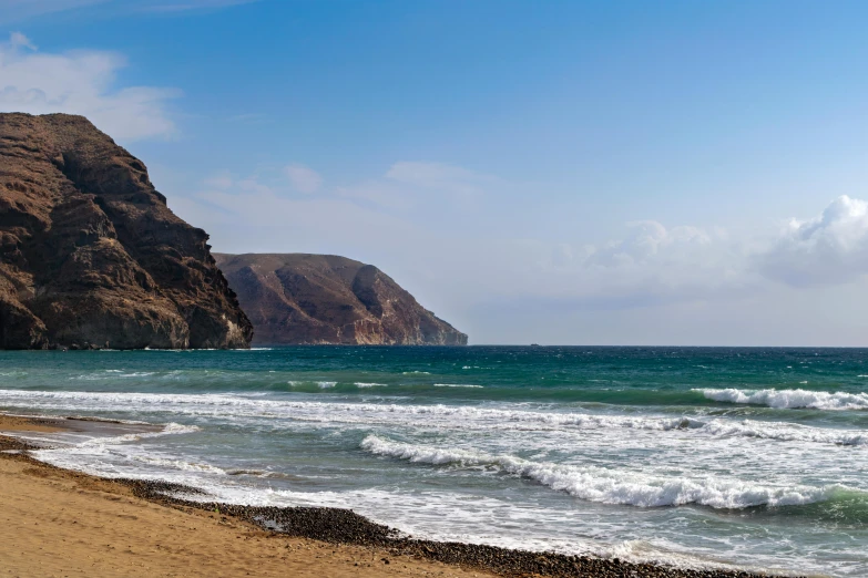 a man riding a surfboard on top of a sandy beach, black volcano afar, square, coastal cliffs, spanish