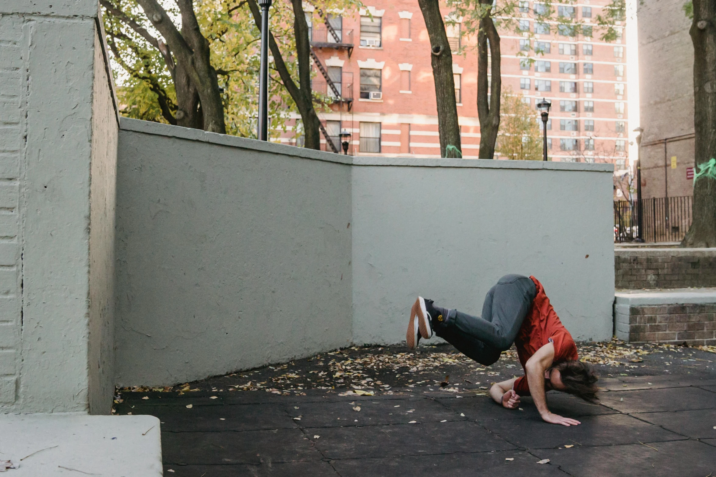 a person doing a handstand on a sidewalk, by Jessie Algie, brett goldstein, in a rooftop, jc park, ryan jia