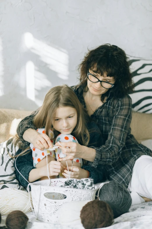 a woman and a little girl sitting on a bed, pexels contest winner, box, crafts and more, teenager hangout spot, patterns