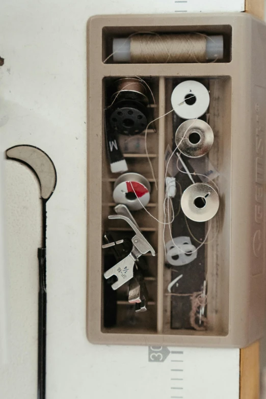 a sewing machine sitting on top of a wooden table, fishing pole, knolling, white broom closet, up close image