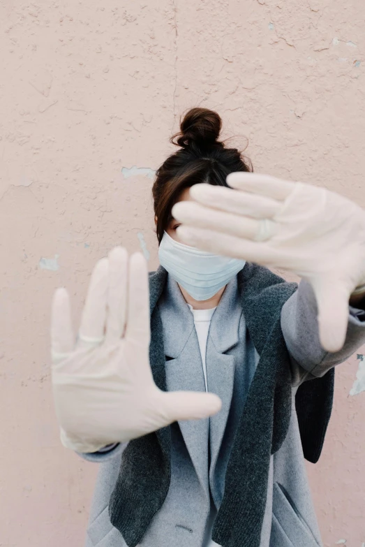 a woman wearing a face mask and gloves, a picture, trending on pexels, happening, greeting hand on head, hands straight down, instagram picture, white coat