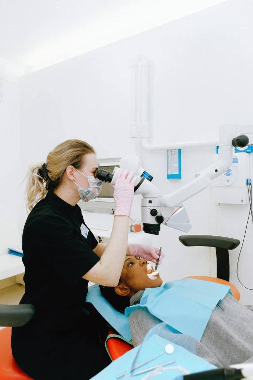 a woman getting her teeth examined by a dentist, pexels contest winner, renaissance, light source on left, london, black, wearing facemask