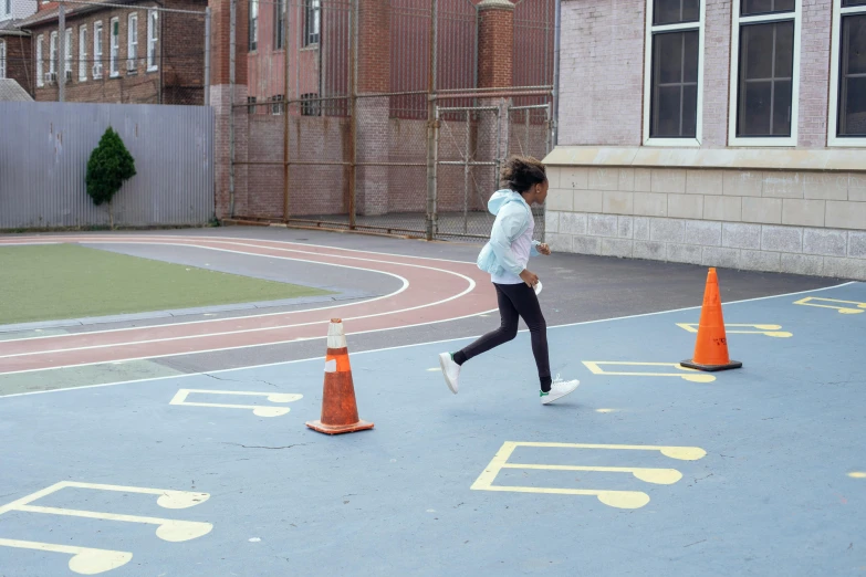 a woman running across a street next to traffic cones, ashcan school, chillhop, school courtyard, promo image, epk