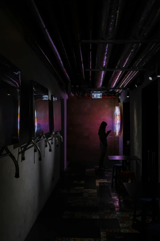 a woman is standing in a dark hallway, a hologram, unsplash, dimly lit dive bar, purple lights, photographed for reuters, depressing image
