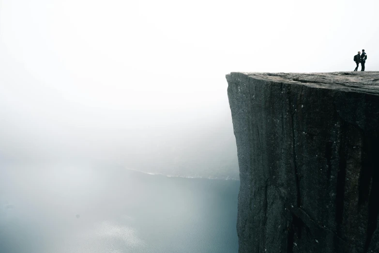 a couple of people standing on top of a cliff, pexels contest winner, postminimalism, gray fog, nordic, ((monolith)), extreme perspective