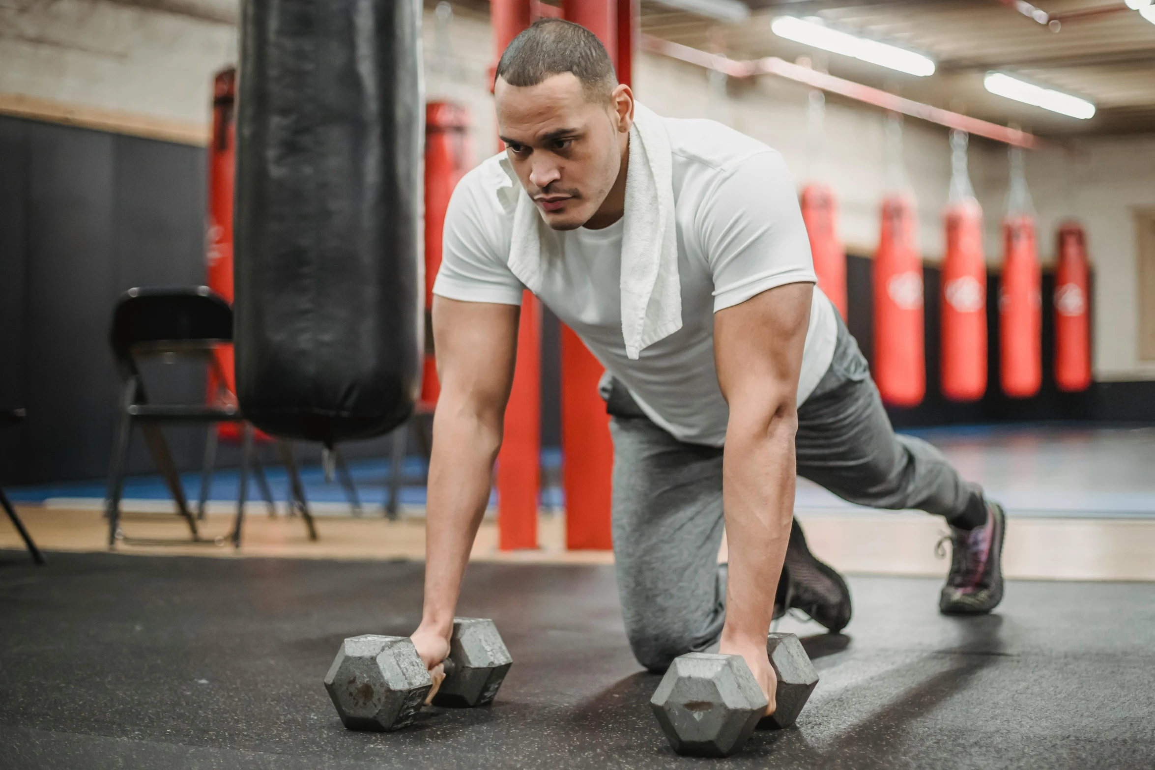 a man doing push ups with dumbbells in a gym, a portrait, by Sebastian Vrancx, pexels contest winner, profile pic, background image, ronaldo nazario, vin diesel with a tummy