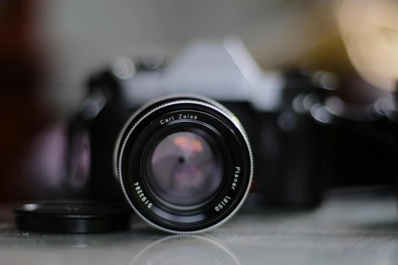 a close up of a camera on a table, by Cafer Bater, pexels contest winner, photorealism, medium format. soft light, zeiss lenses, 3 5 mm!!!!! lens, lensflare