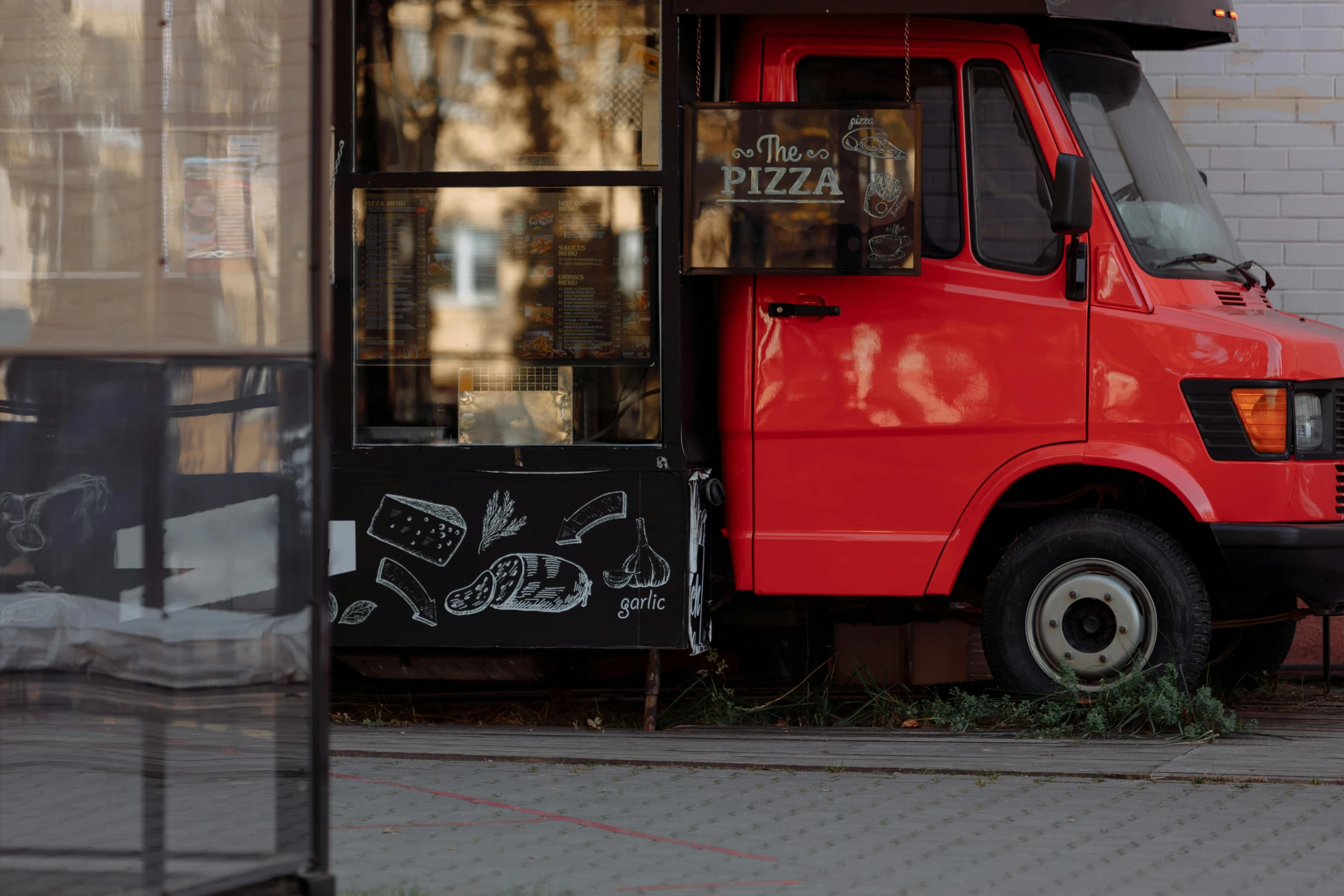 a red food truck parked in front of a building, by Adam Marczyński, pexels contest winner, pizza on a table, red - black, without text, shop front