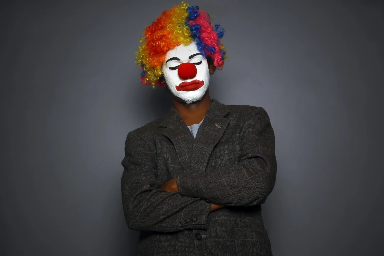 a man dressed as a clown with his arms crossed, a portrait, pexels, jeffrey wright, polychromatic, gray men, album