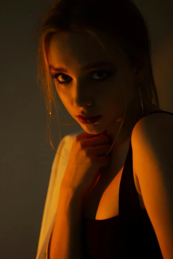 a woman posing for a picture in the dark, inspired by Elsa Bleda, glowing orange eyes, sydney sweeney, cinematic. by leng jun, highkey lighting