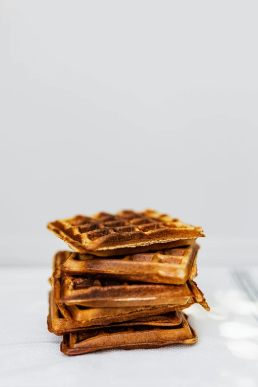 a stack of waffles sitting on top of a table, black on white background, jen atkin, medium shot angle, front facing