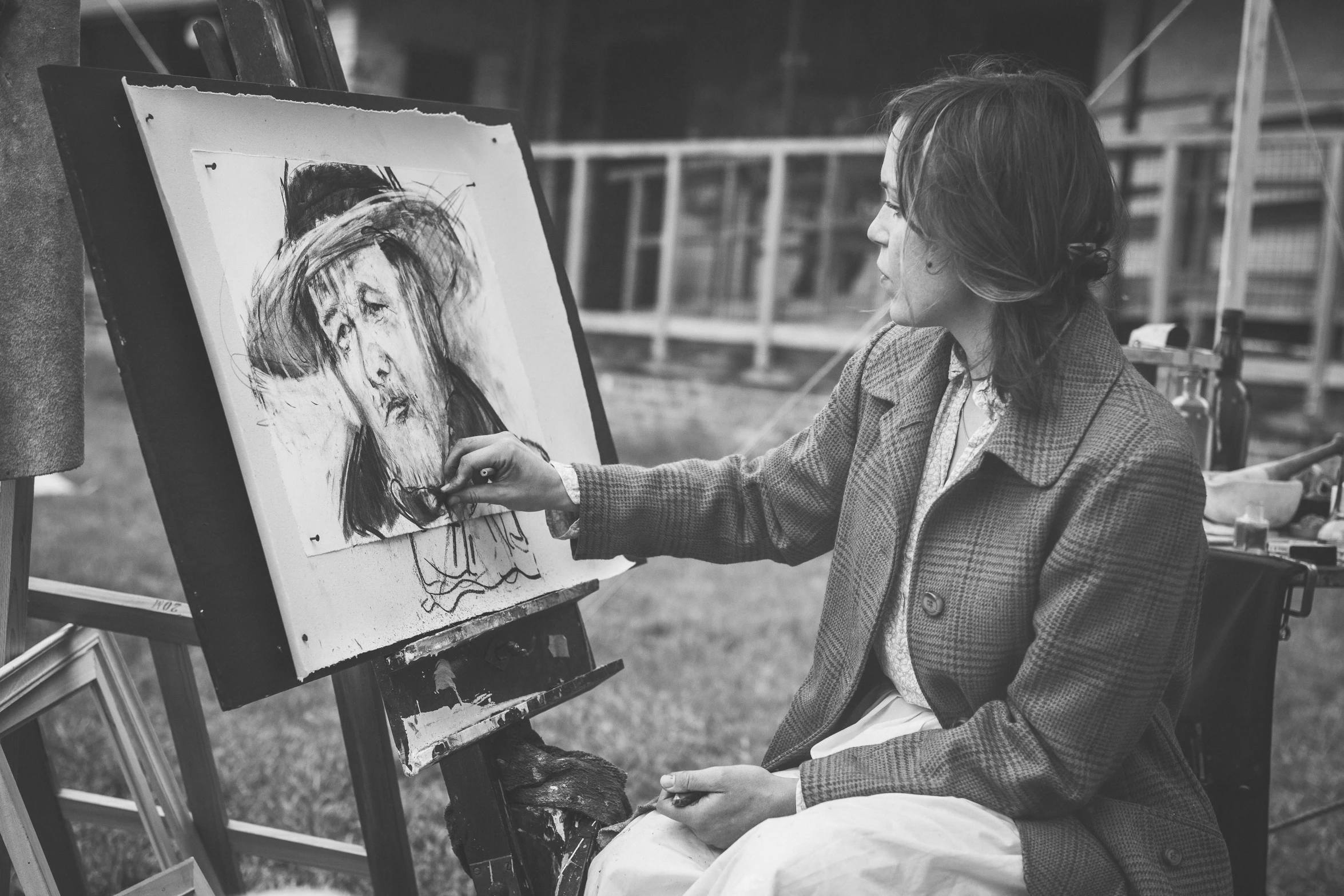 a black and white photo of a woman painting, a charcoal drawing, by Dariusz Zawadzki, pexels, visual art, caracter with brown hat, caricaturist, easel, van gogh painting