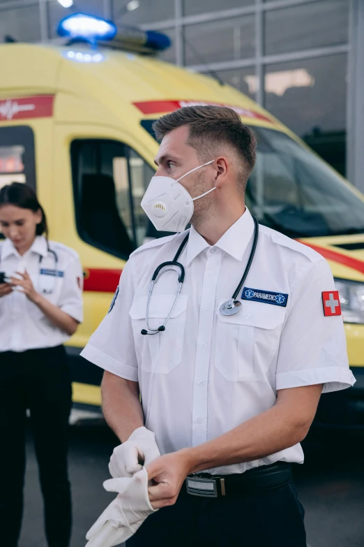 a group of medical workers standing in front of an ambulance, a picture, by Adam Marczyński, pexels, embroidered uniform guard, 🚿🗝📝, profile image, a person standing in front of a