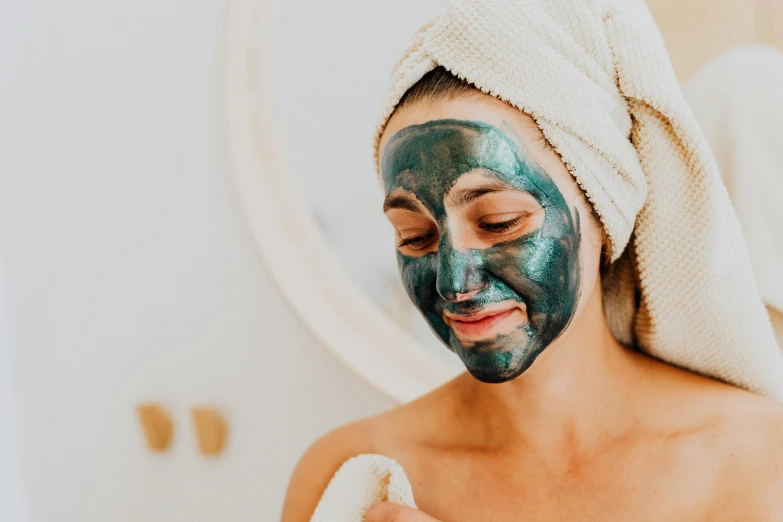 a woman with a towel wrapped around her head, by Emma Andijewska, trending on pexels, face paint, eucalyptus, shiny and sparkling, having a good time