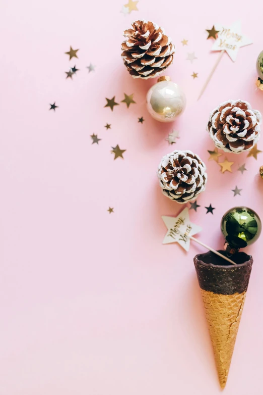 a bunch of pine cones sitting on top of a pink surface, by Julia Pishtar, trending on unsplash, dressed in stars and planets, candy decorations, bubbly, hanging
