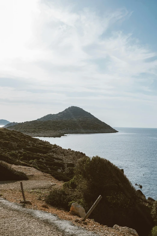 a motorcycle parked on the side of a road next to a body of water, by Exekias, unsplash contest winner, les nabis, panorama distant view, ibiza, walking down, pyramid surrounded with greenery