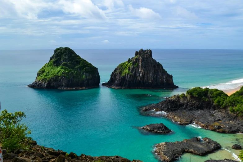 a group of people standing on top of a hill next to a body of water, a matte painting, by Peter Churcher, pexels contest winner, tropical ocean, rock arcs, two medium sized islands, portugal