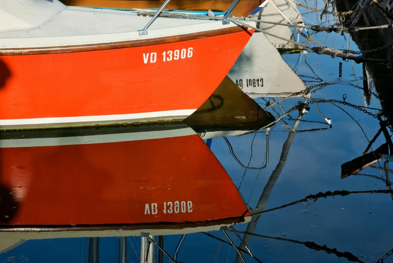 a red and white boat sitting on top of a body of water, by Eglon van der Neer, pexels contest winner, reflective scales, three masts, orange and white, close together