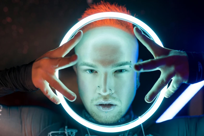 a man holding a light up in front of his face, by Joe Bowler, pexels contest winner, holography, orange head, circular face, pewdiepie, photo from a promo shoot