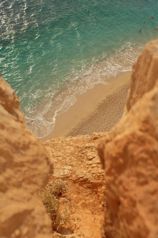 a view of a beach from the top of a cliff, by Daren Bader, middle eastern details, golden hues, slide show, explore