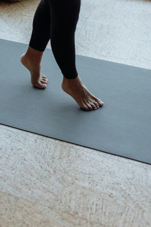 a woman standing on a yoga mat in a living room, by Carey Morris, unsplash, arabesque, detailed close foot shot, running freely, hyper realistic detail, slate