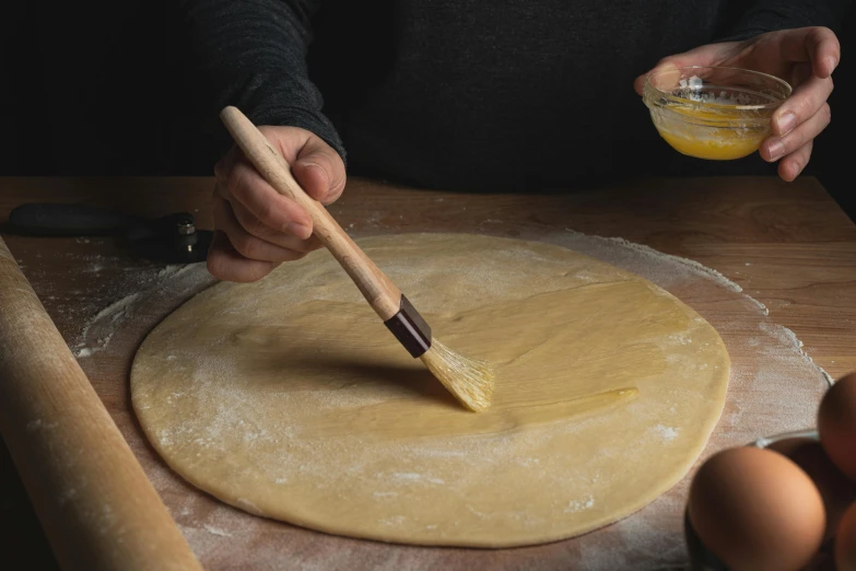 a person using a brush to make a dough, inspired by Géza Dósa, gloss finish, apple pie, lpoty, no cropping