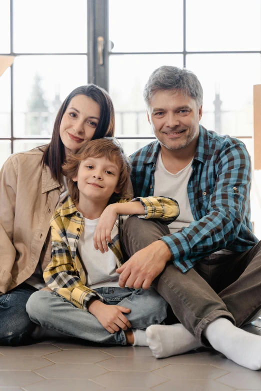 a man and woman sitting on the floor with a child, looking confident, fertility, teen boy, spy x family